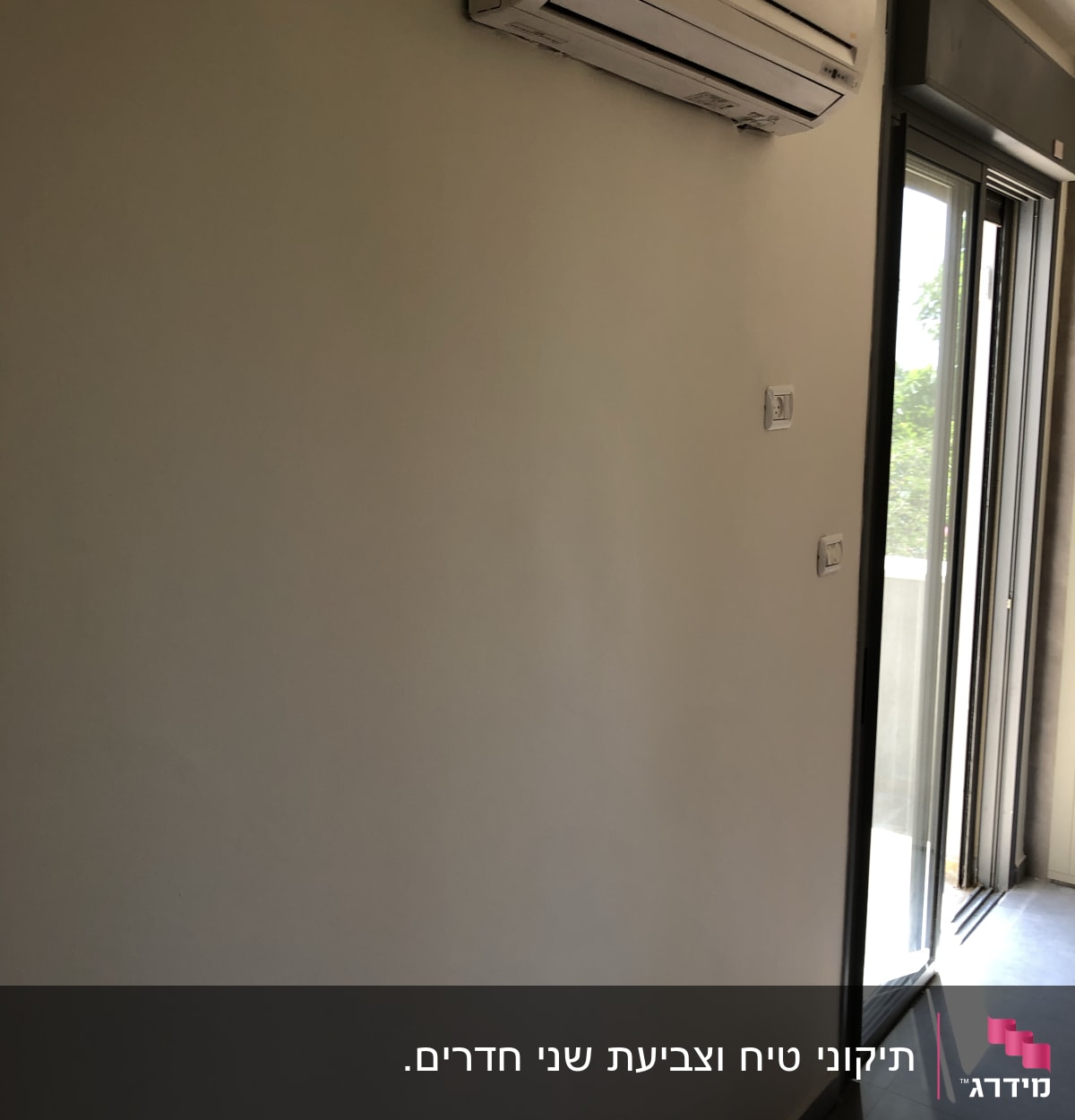 קיר צבוע בלבן ליד מזגן ודלת זכוכית